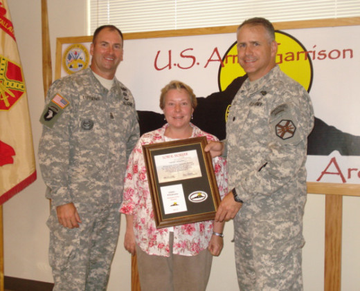 Lori Horner, assistant executive officer, accepts an employee of the quarter award from Lt. Col. Eric Shwedo (right), commander, PTA, and PTA Command Sgt. Maj. Jonathan Lutgens (left), during a recent ceremony. (Photo courtesy of Pohakuloa Training Area)