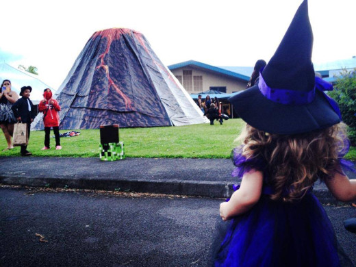 Young witch looks towards a large, volcanic attraction during the New Hope Christian Fellowship event held on Halloween night. The volcano eventually erupted candy. 