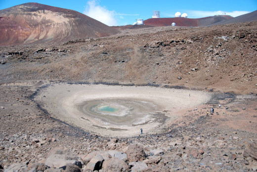 USGS Photo, looking north, at what remained of Lake Waiau on September 26, 2013.  The water area was just 15 meters (yards) wide at this time.  Prior to 2010, the lake occupied the entirety of the now-dry lake bed, which is about 100 meters (yards) wide. The astronomical telescopes at the summit off Mauna Kea are visible on the skyline. 