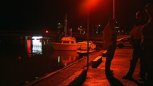 small group gathers at Wailoa Small Boat Harbor to watch the tides