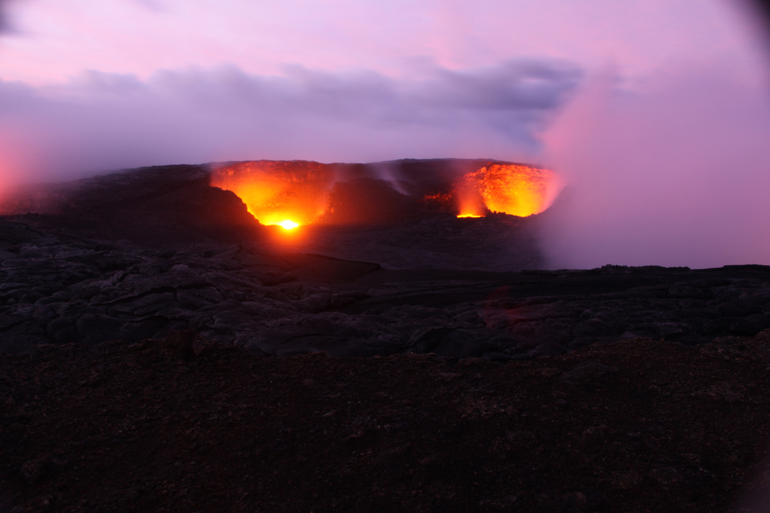 A time-lapse camera on the rim of Puʻu ʻŌʻō crater captured this image at dawn. The view is towards the southeast, and shows two glowing pits in the southern portion of the crater floor. CREDIT: USGS HVO