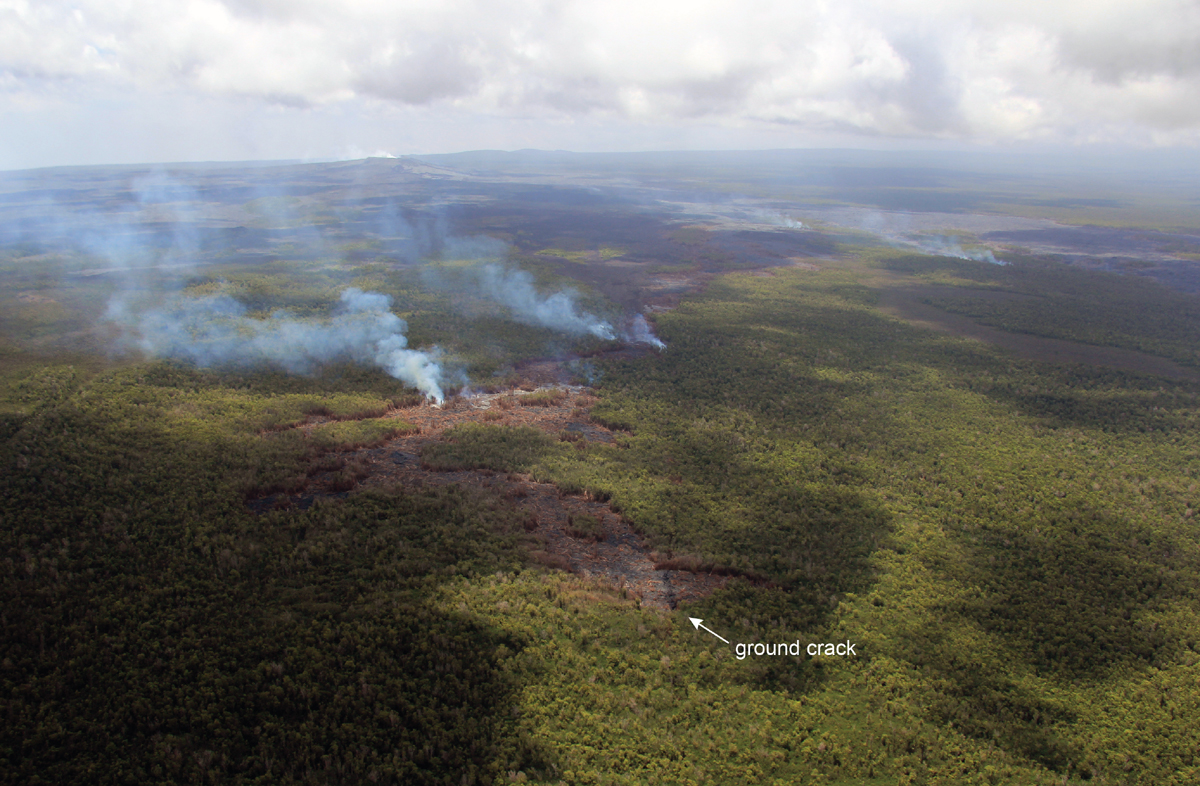 A closer view of the southern lobe of the June 27th lava flow. Smoke plumes originate from active surface breakouts, the farthest today reached 8.5 km (5.3 miles) from the vent on Puʻu ʻŌʻō. The spot at which this lobe plunged into a deep ground crack last week can be seen near the bottom of the photograph. In the upper right portion of the photograph, smoke originating from active breakouts on the northern lobe can be seen. (USGS HVO)