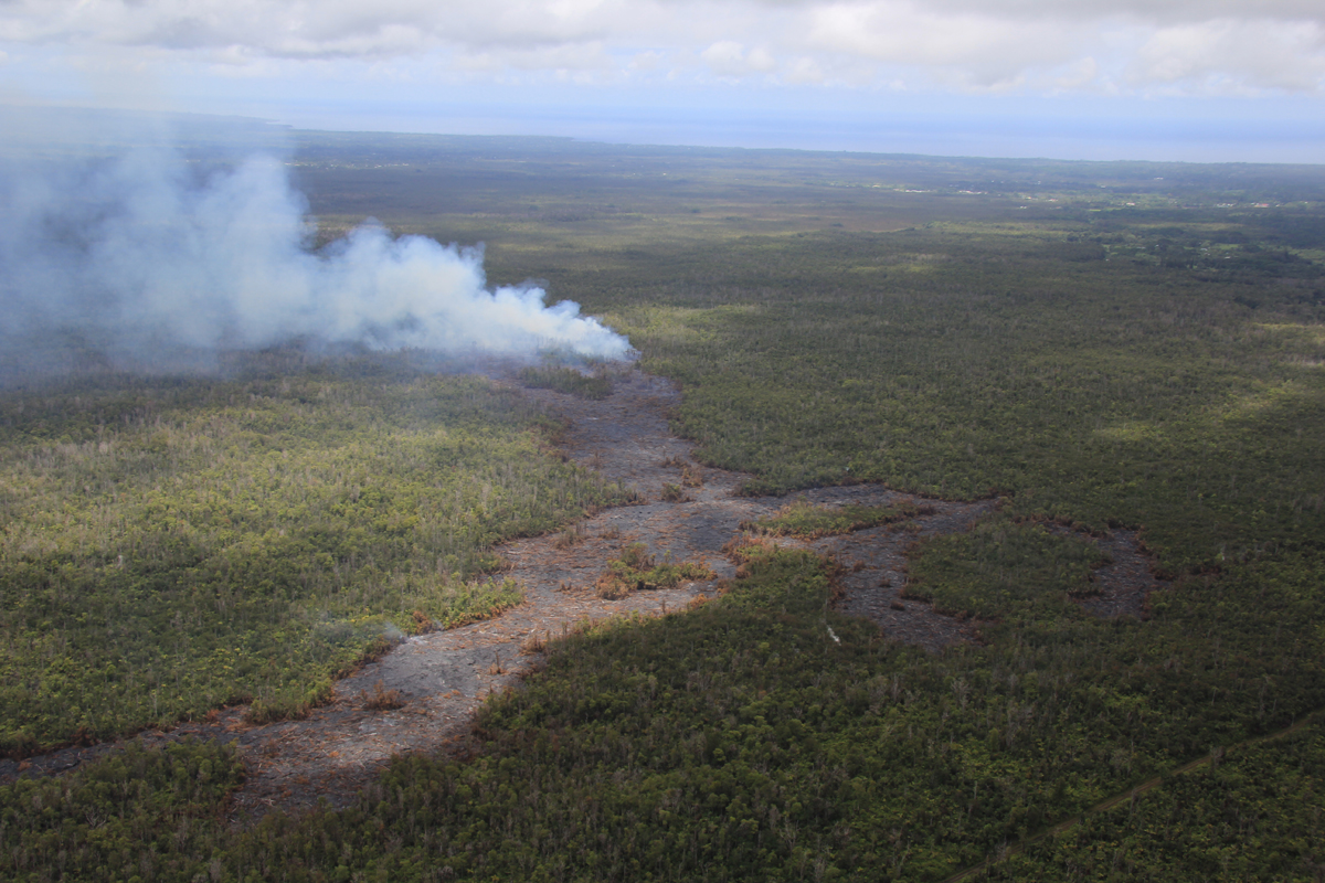 (USGS HVO on Sept. 8) This view shows the active flow front from behind. The lava feeding the flow emerges from a crack parallel to the road at lower right, which goes to the True/Mid-Pacific geothermal well site. Kaohe Homesteads is to the right, Pāhoa is at the upper right, and Ainaloa and Hawaiian Paradise Park are at upper left.