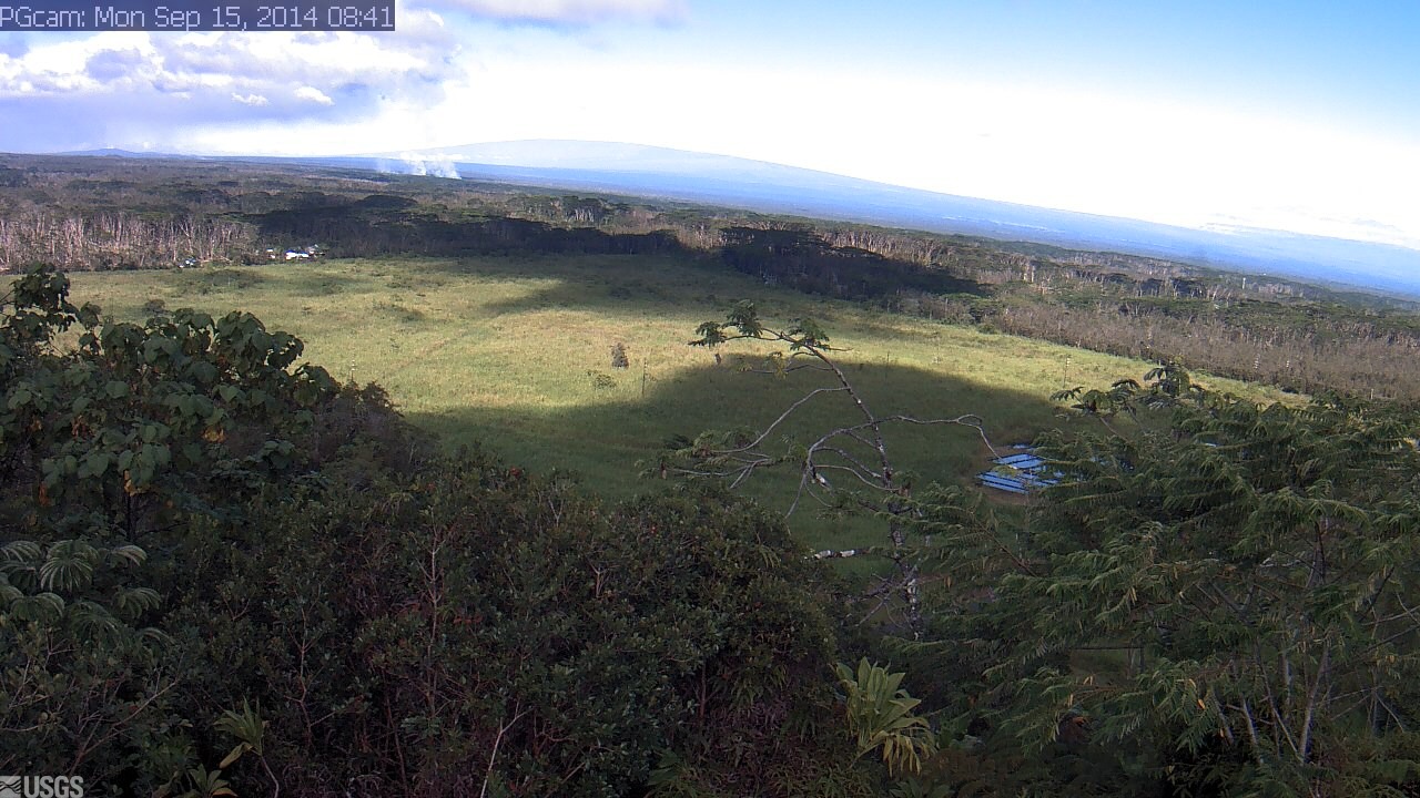 This USGS Hawaiian Volcano Observatory image is from a research camera positioned near Kapoho looking northwest. The advancing front of the June 27th lava flow is seen on the horizon, burning vegetation and sending smoke aloft in left center of the image.