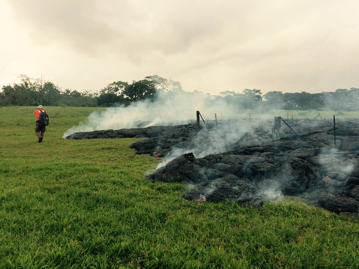 An HVO geologist maps the margin of the June 27th lava flow in the open field below Apaʻa Street / Cemetery Road. This photo is courtesy USGS HVO.