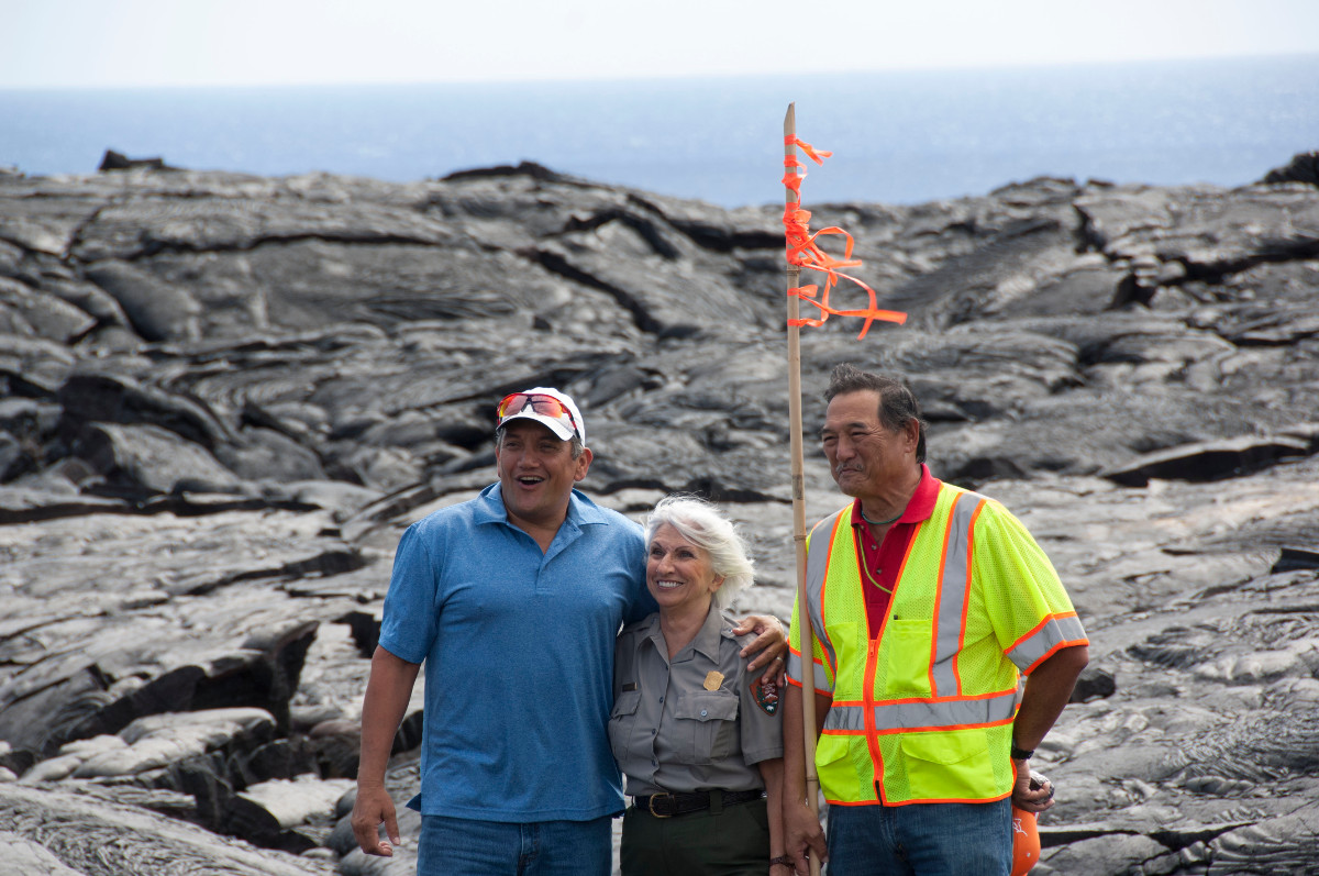 Mayor Billy Kenoi, County Public Works Director Warren Lee, and Hawaii Volcanoes National Park superintendent Cindy Orlando arm-in-arm in celebration, courtesy National Park Service