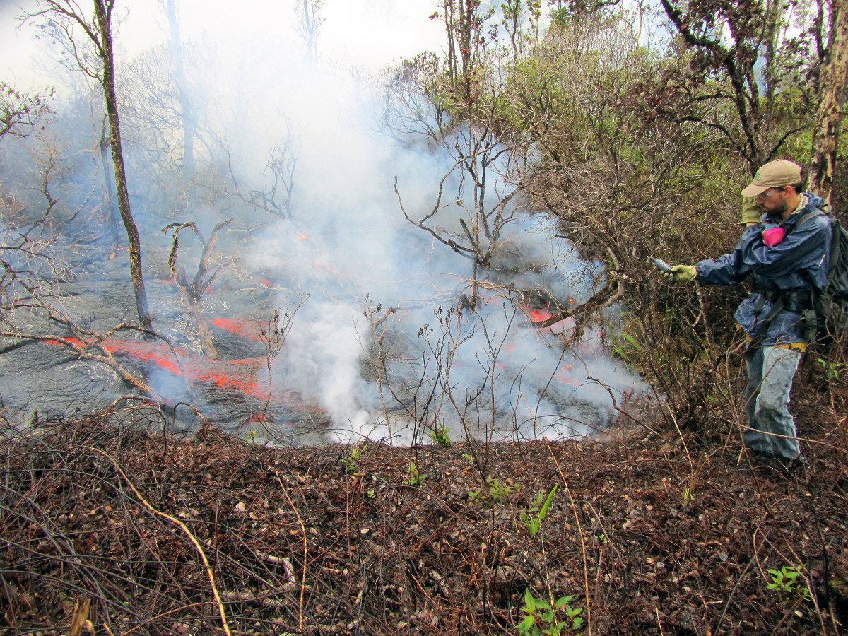 An HVO geologist uses a handheld GPS unit to mark the flow margin coordinates. The flow field map today was updated by taking a series of GPS points like this around the leading portion of the flow. (USGS photo)