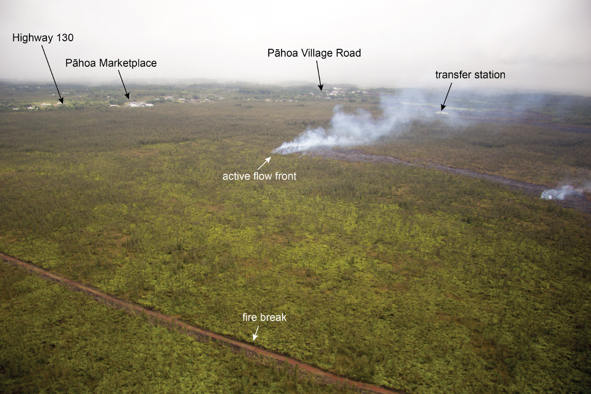 This USGS photograph looks downslope towards Pāhoa, and shows the active flow front moving through dense vegetation upslope of Pāhoa Marketplace and Highway 130.