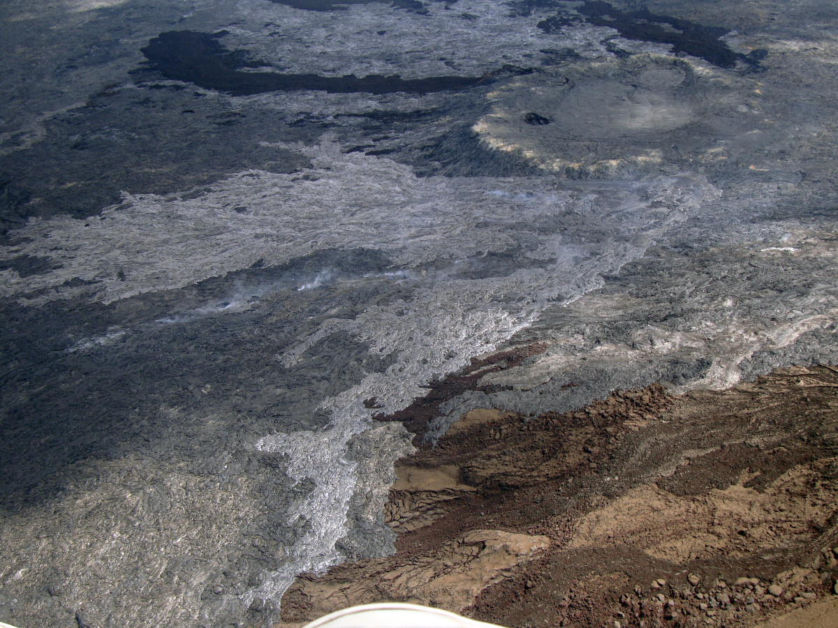 Feb. 23, 2015 (USGS) The new breakout, visible as the lighter colored region in the center of the photograph, occurred from the area of the June 27th vent (upper right portion of photograph).