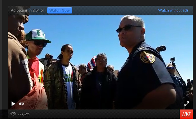 Police speak to TMT opponents blocking the road.  Image from live video streamed from the scene by Kerri Marks with Occupy Hilo