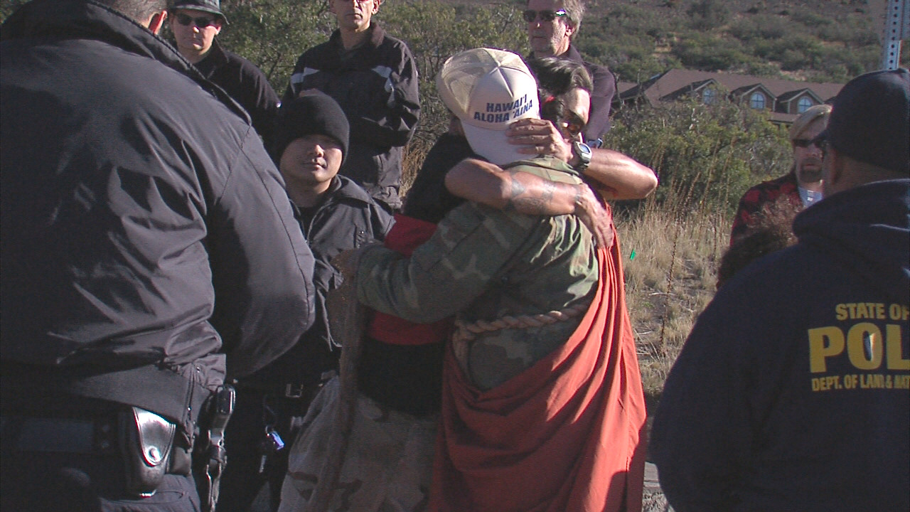 Kahookahi Kanuha of Kailua-Kona hugs a friend before being handcuffed Thursday on Mauna Kea.