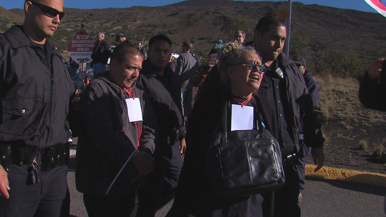 Moanikeala Akaka and Eric Heaukulani taken away by police. Akaka made it known she did not appreciate the handcuffs.