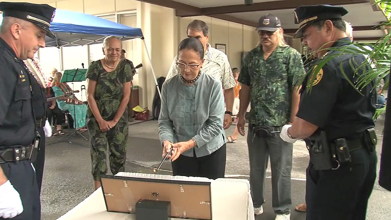  Momi Cazimero, the sister of Ronald “Shige” Jitchaku, lights a memorial candle. Image courtesy HPD.