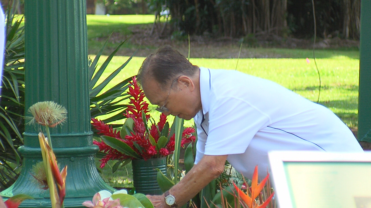 Takayoshi Kanda places flowers at the base of the clock.