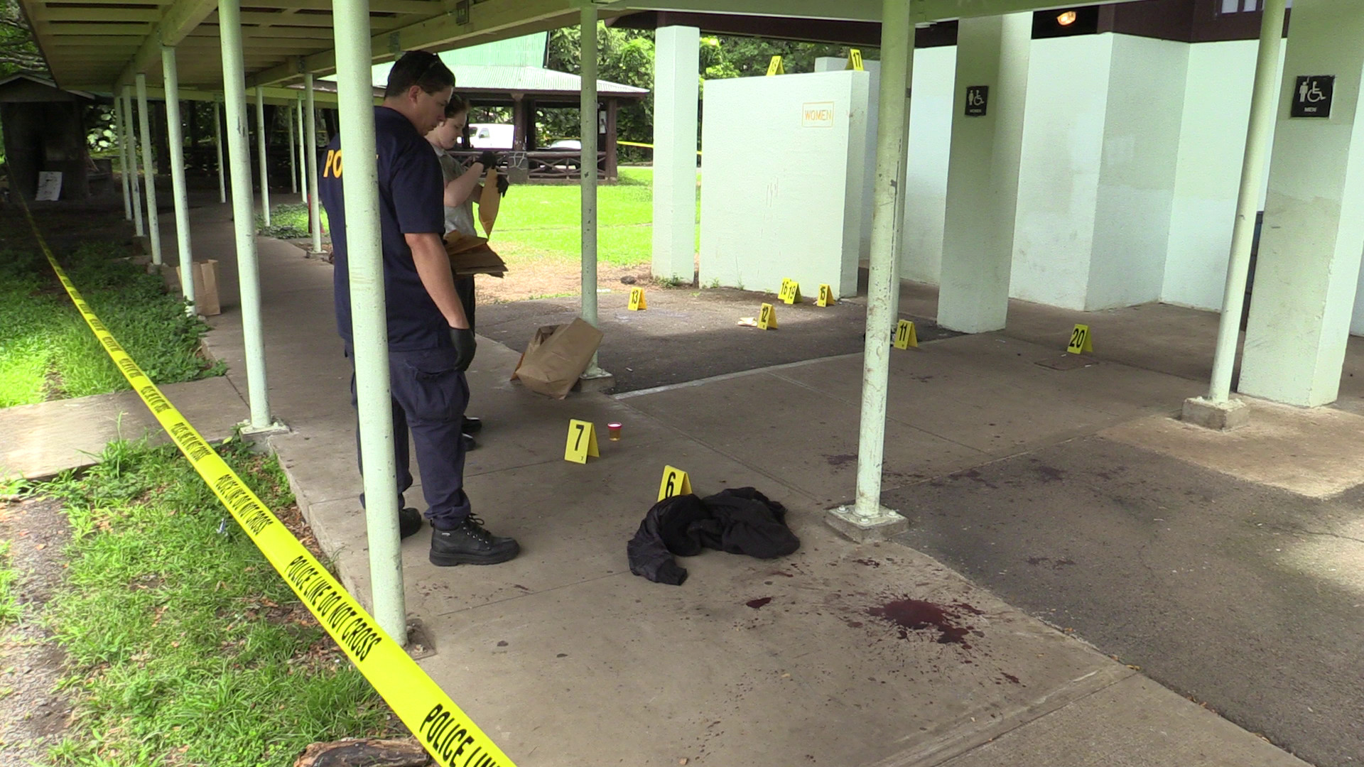 Hawaii Co. Police detectives and technicians work the crime scene at Wailoa State Park on Monday. Photography by Daryl W. Lee.