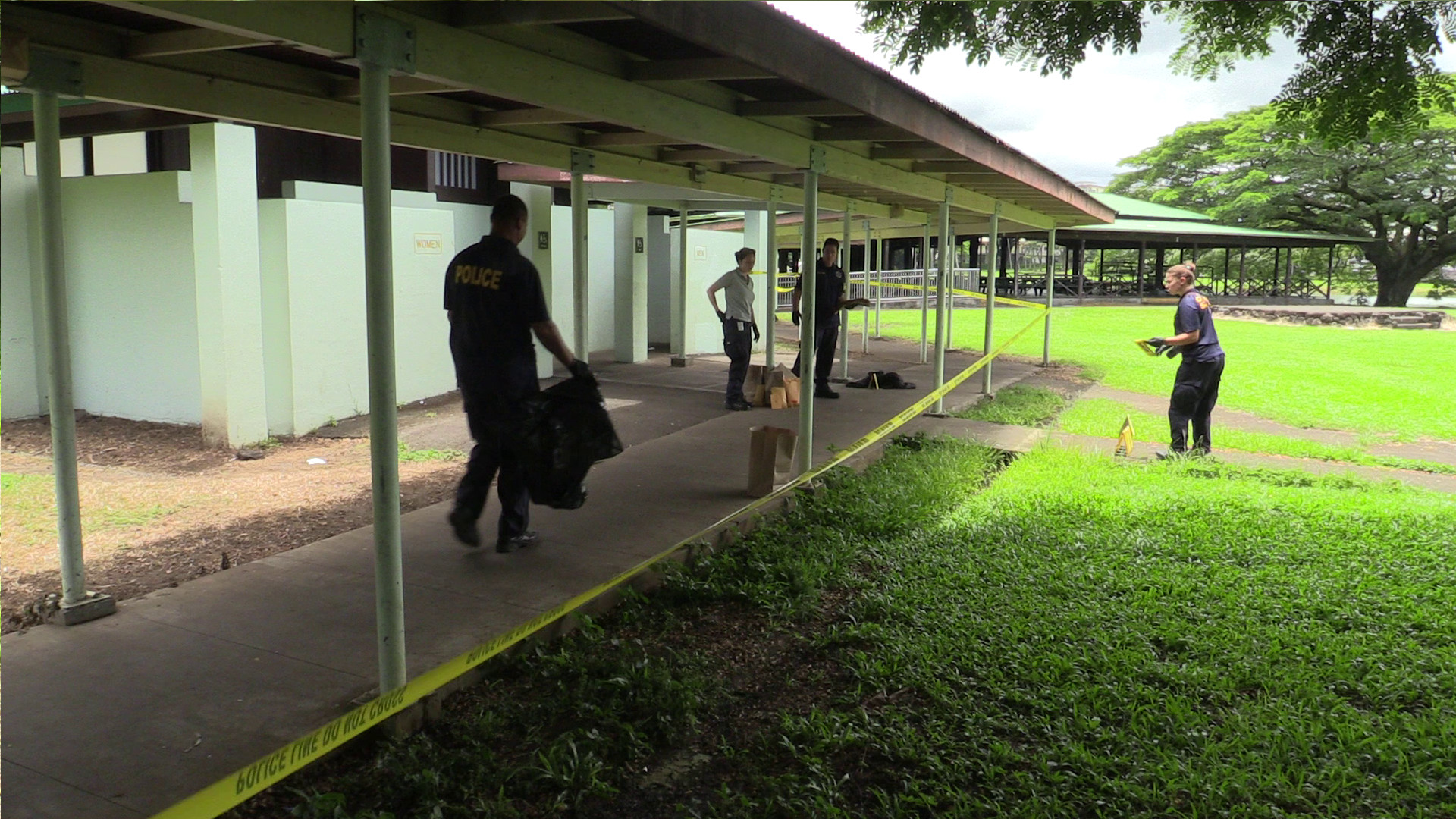 Hawaii Co. Police detectives and technicians work the crime scene at Wailoa State Park on Monday. Photography by Daryl W. Lee.