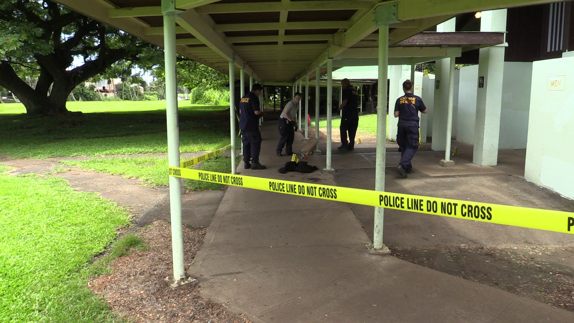 Hawaii Co. Police detectives and technicians work the crime scene at Wailoa State Park on Monday. Photography by Daryl W. Lee.
