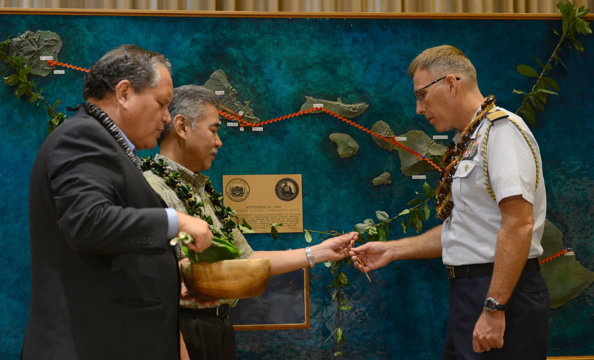 Kahu Kelekona Bishaw leads David Ige, Hawaii state governor, and Capt. James Jenkins, Coast Guard 14th District chief of staff, through a ceremonial blessing. (photo courtesy U.S. Coast Guard)