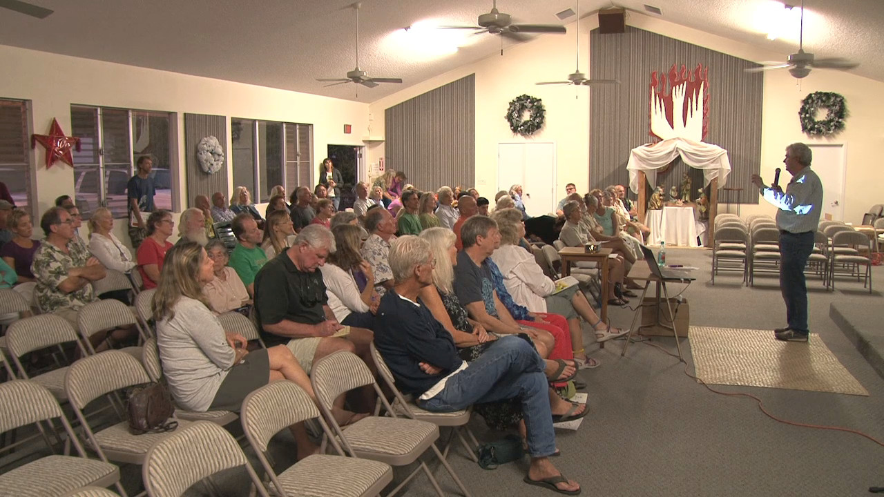 The community meets at the Painted Church to talk about the dengue fever outbreak.