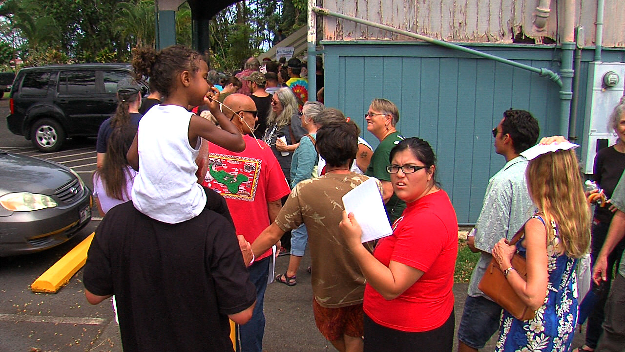 People inch forward in a line that stretched around the Keaau Community Center.