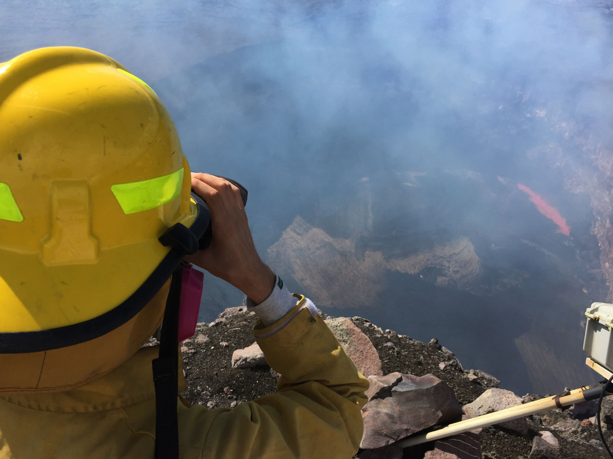 HVO geologist uses a laser rangefinder to measure the depth of the lava lake at the summit of Kīlauea in the Overlook crater.  (USGS Hawaiian Volcano Observatory photo)