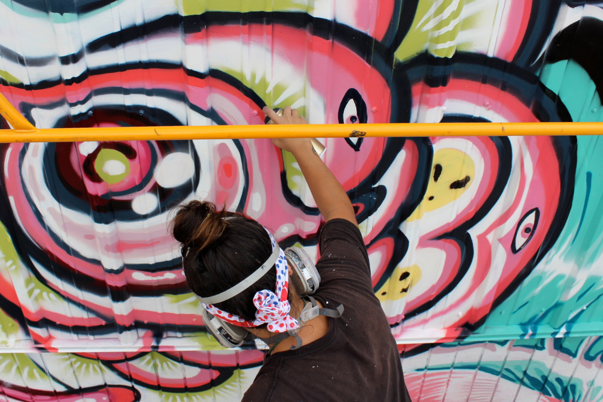 Lauren YS paints her mural in Hilo. Photo by Miya Tsukazaki.