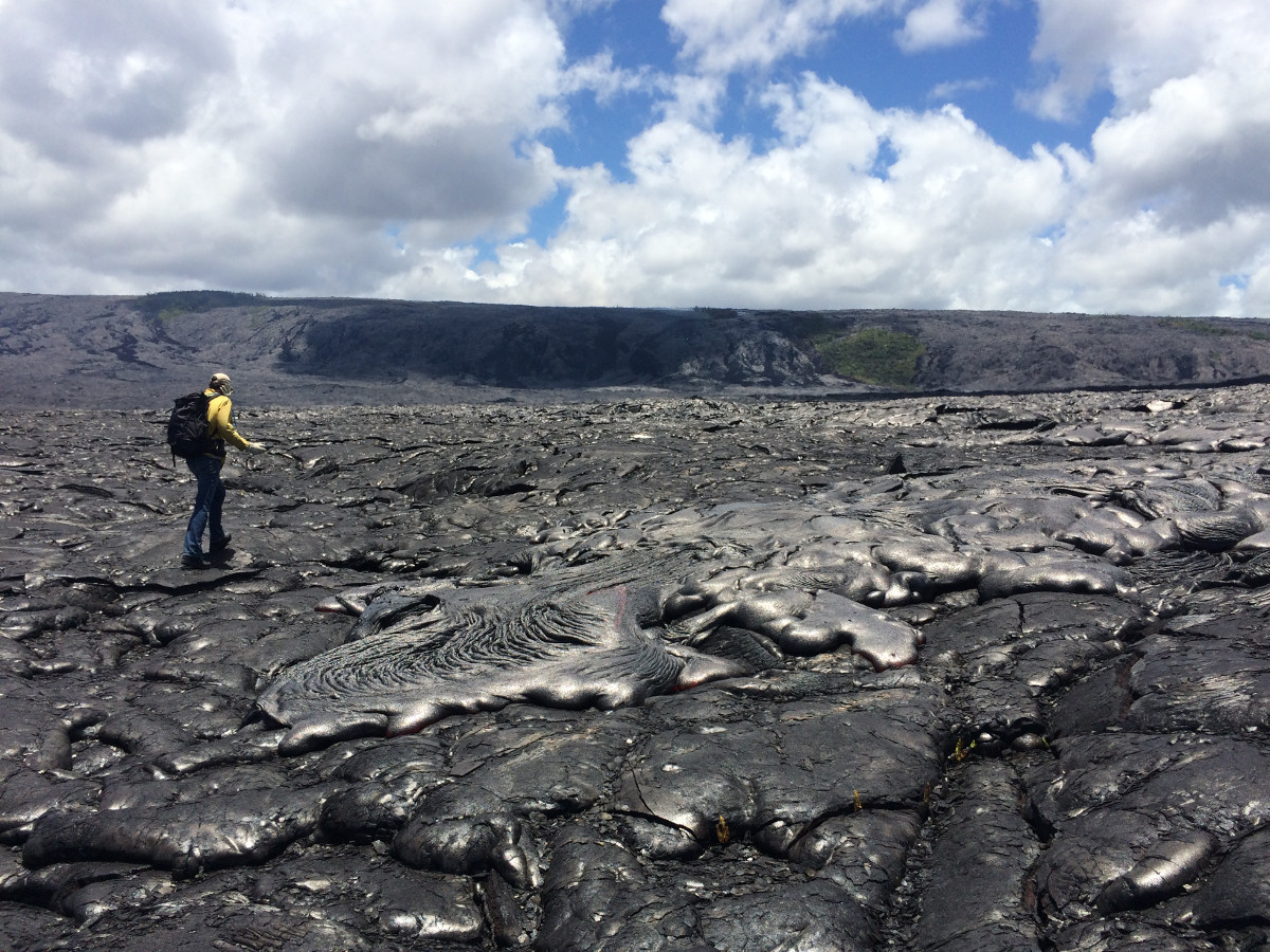 (USGS photo) An HVO geologist maps the flow margin using a handheld GPS unit. 