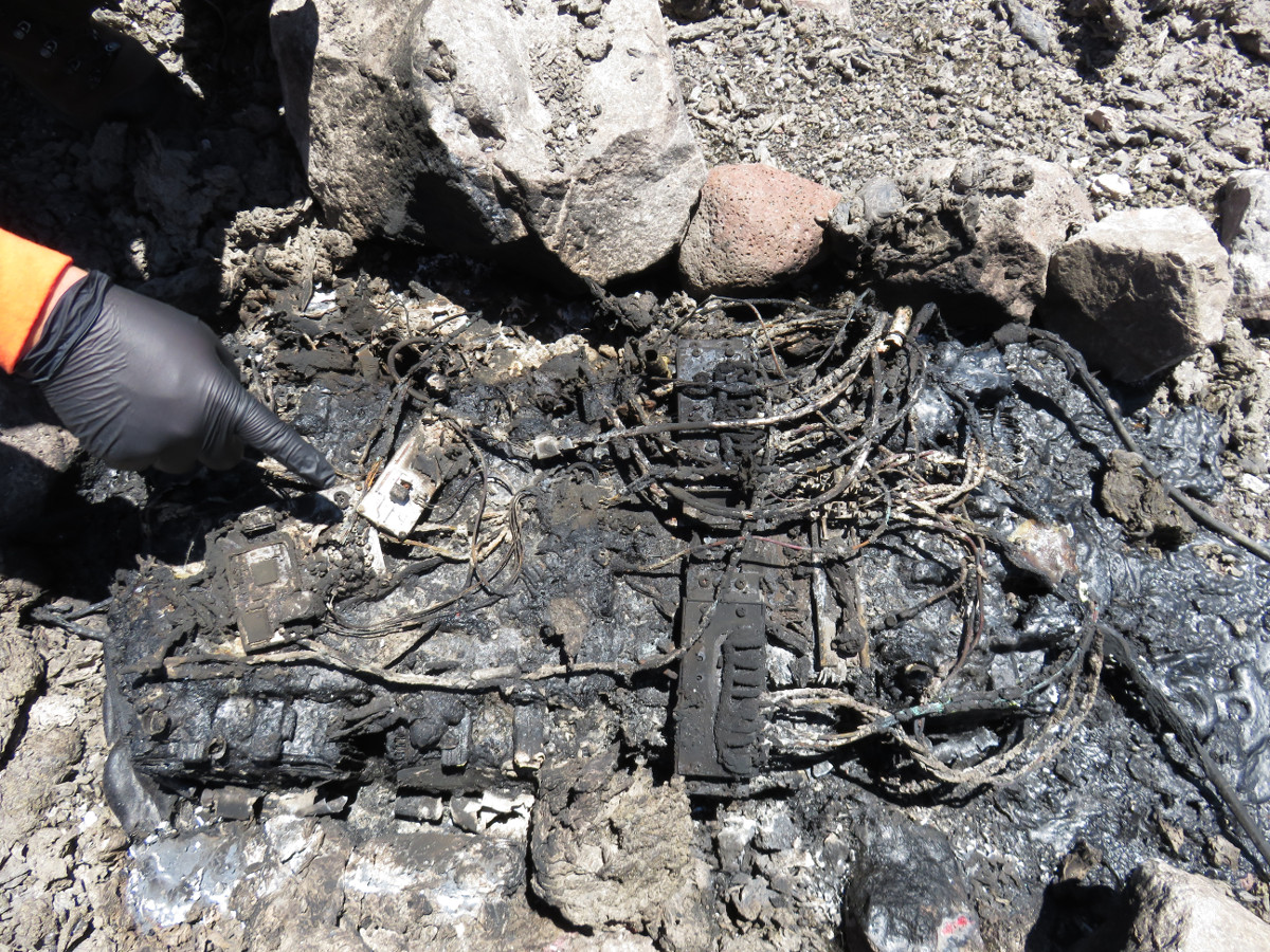 (USGS photo) This pile of charred wires and metal components, surrounded by melted plastic, is all that remains of the power supply for one of HVO's gravity instruments located about 24 m (80 ft) from the crater rim.