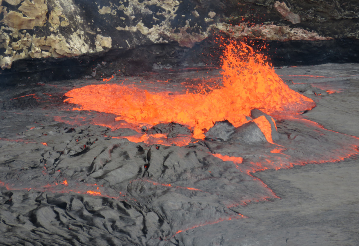 (USGS photo) Zoomed in view of the spattering at the south edge of the lava lake. Note the black high-lava mark from this morning on the wall just behind the spattering.