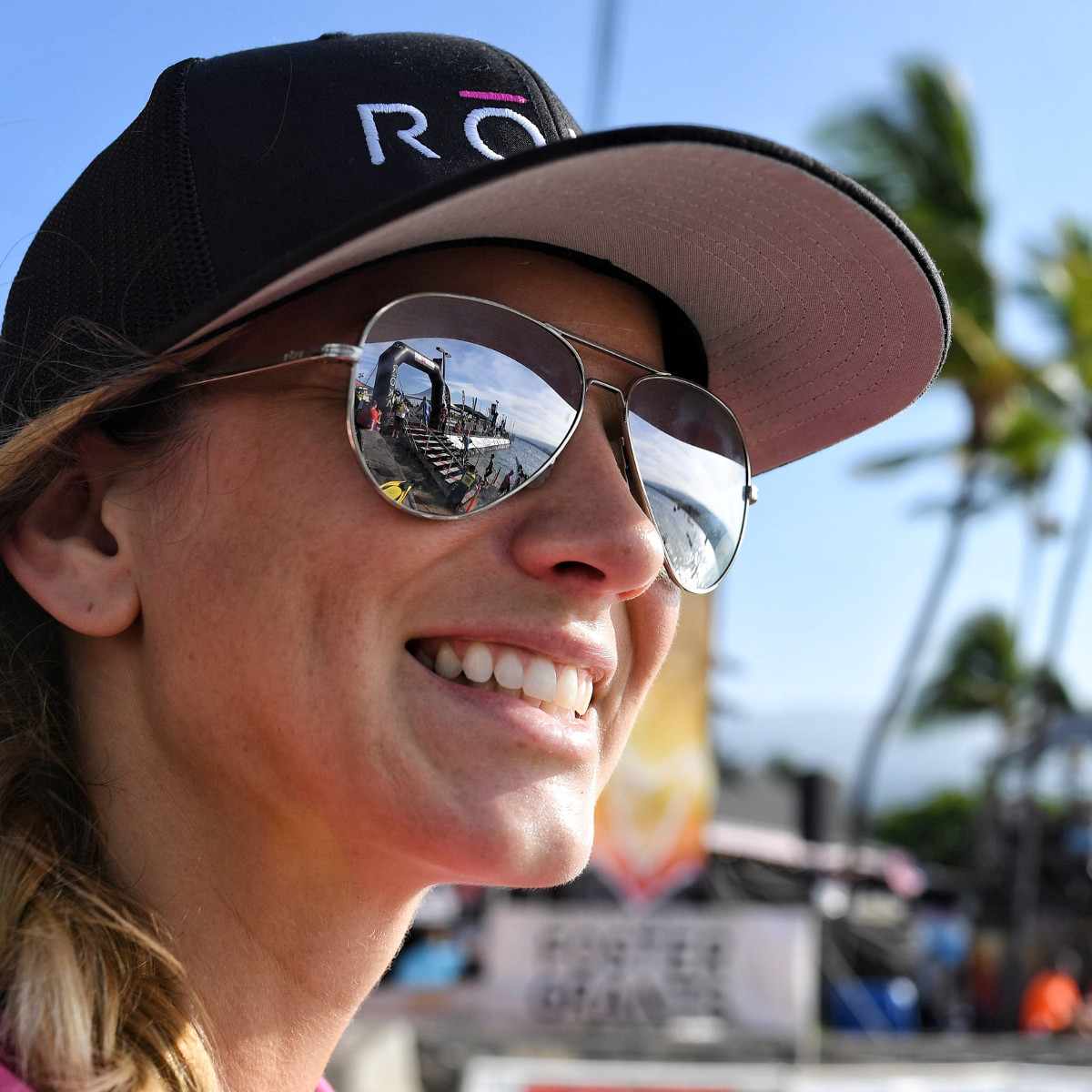 JUST KEEP SMILING. One of thousands of spectators “reflects” as she enjoys the incredible accomplishment of athletes exiting the 2.4-mile swim at the IRONMAN World Championship in Kailua-Kona, Hawai`i (Nils Nilsen/Roka Sports) – Copyright © 2016 IRONMAN, All rights reserved.