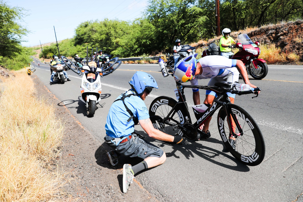 STOP AND GO. An athlete stops for repairs along the 112-mile bike course before heading back out to compete at the 2016 IRONMAN World Championship in Kailua-Kona, Hawai’i. (Tom Pentington/Getty Images for IRONMAN) - Copyright © 2016 IRONMAN