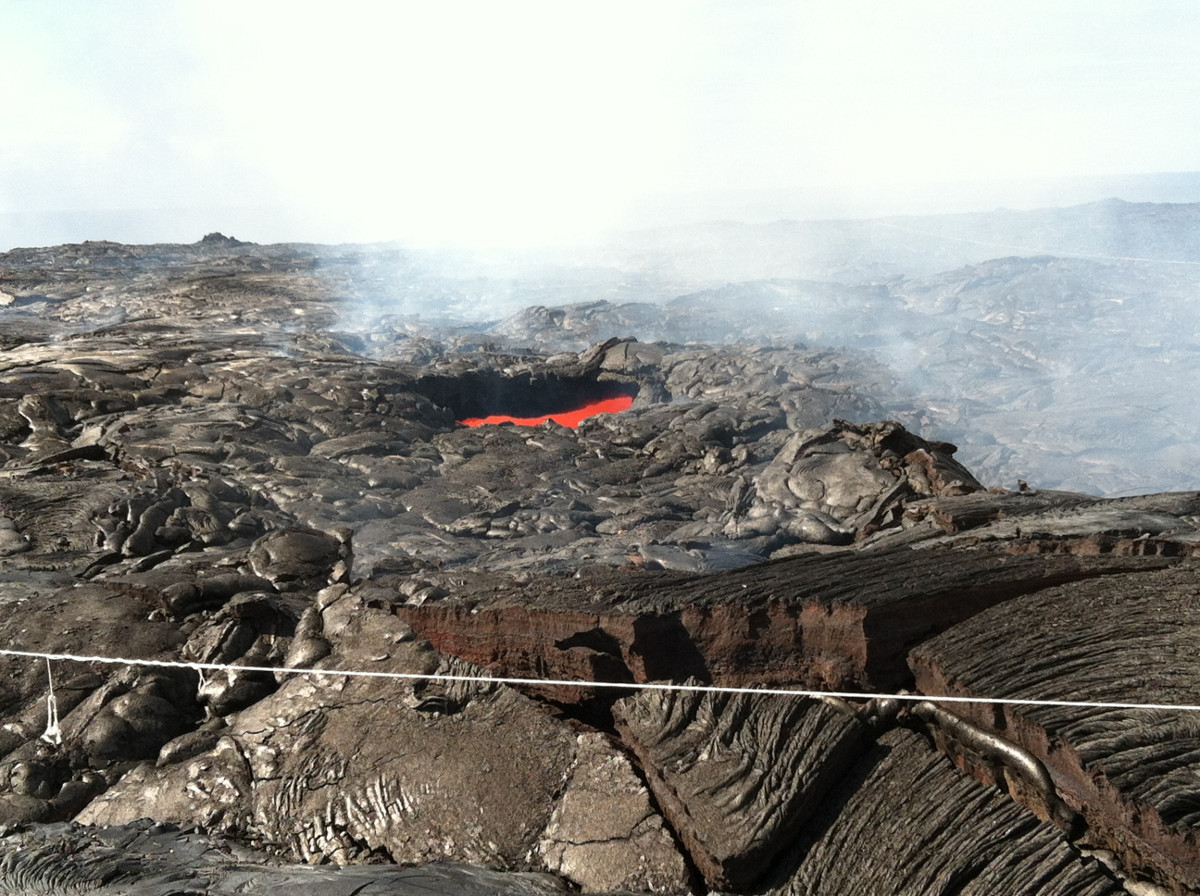 This skylight, a "window" into the active lava tube that carries lava from the vent to the sea, is located inland of the Kamokuna ocean entry. (USGS on October 7, 2016)