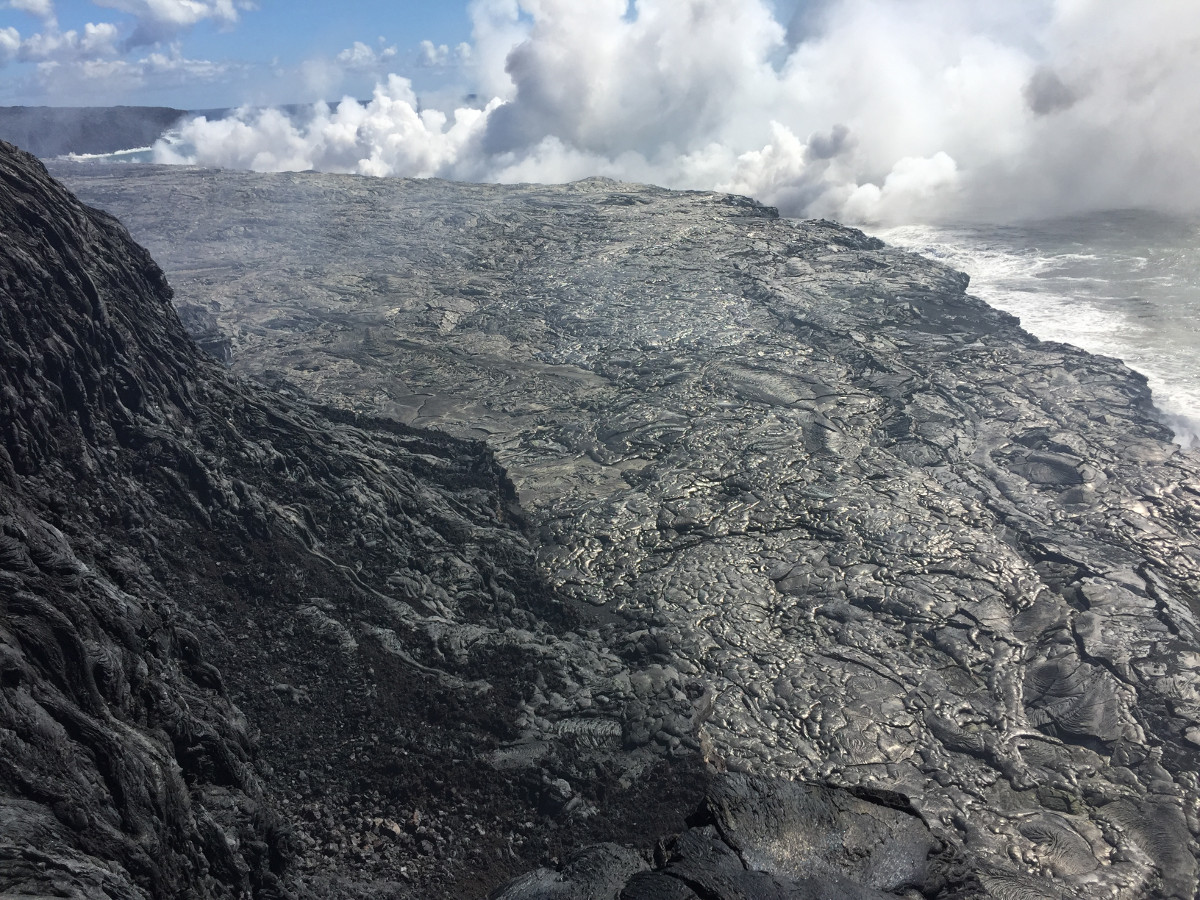 (USGS photo) The east Kamokuna ocean entry was still active on October 25, with multiple entry points spread along the eastern side of the lava delta. Lava dribbling into the sea at the front of the delta creates a billowy white plume, which looks harmless, but is actually a mixture of superheated steam, hydrochloric acid, and tiny shards of volcanic glass.