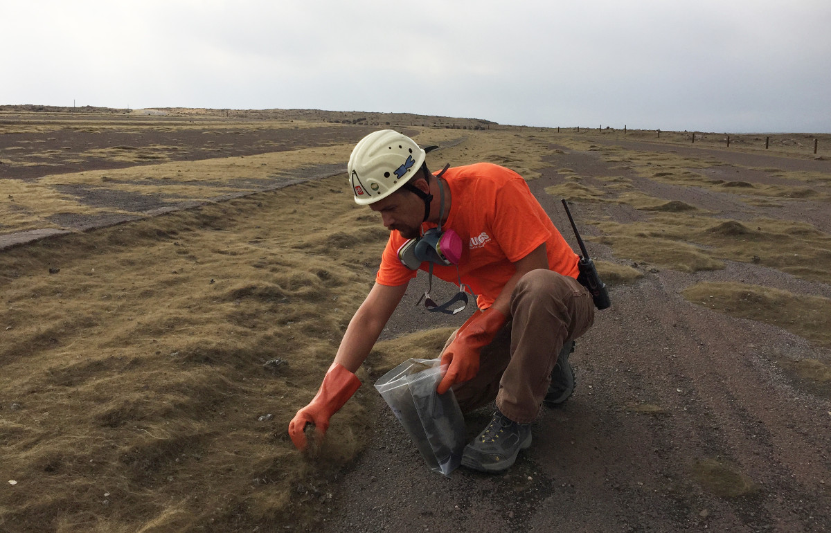 (USGS) A USGS-HVO scientist collects Pele's hair from the parking area south of Halemaʻumaʻu Crater, which has been closed since early 2008 due to ongoing volcano hazards associated with the summit lava lake. His gas mask was at the ready just in case the wind shifted, USGS says.