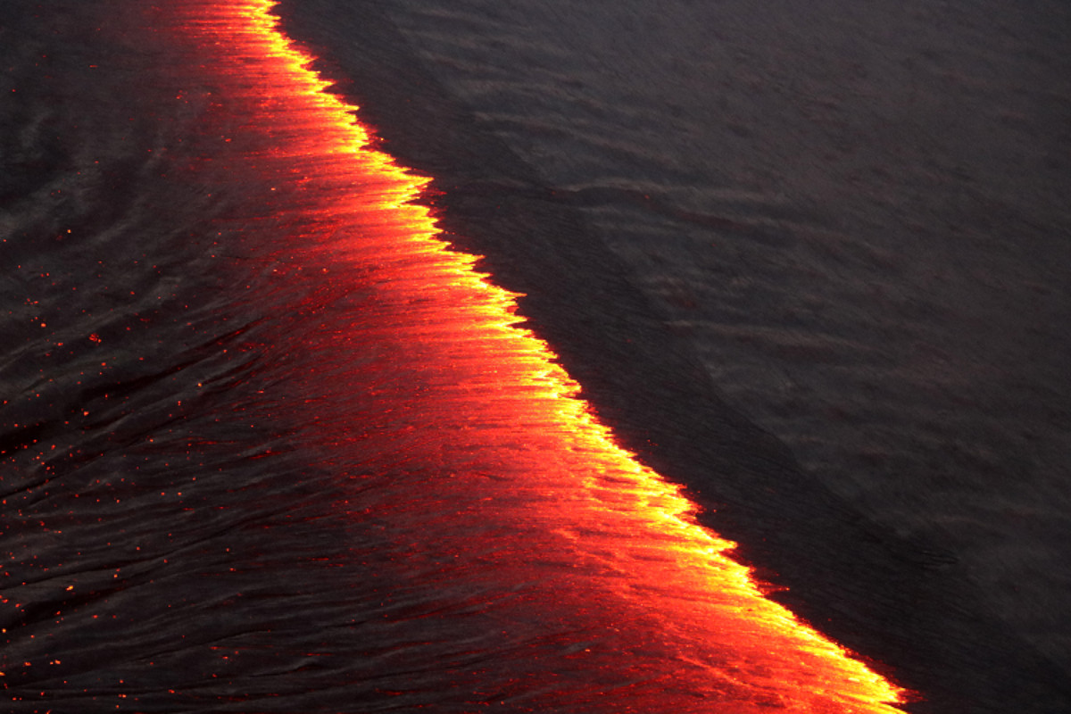 On the lava lake, the crustal plates on both sides of the incandescent line are migrating to the south, but the crust on the left side is moving more rapidly to the south than the crust on the right. As the semi-solid crust pulls apart, molten lava upwells between the two plates to create new crust. (USGS photo)